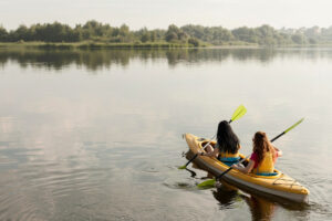 Dos mujeres remando en kayak en la laguna, ofreciendo una actividad de paseo y relax en Palmas de la Laguna.